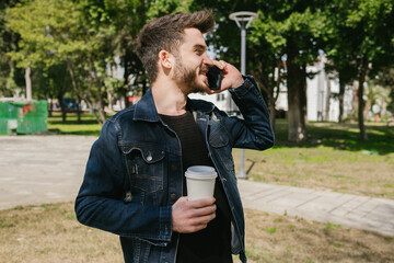 Wall Mural - Voice calling, young man talking on the phone while holding coffee cup, have a good time
