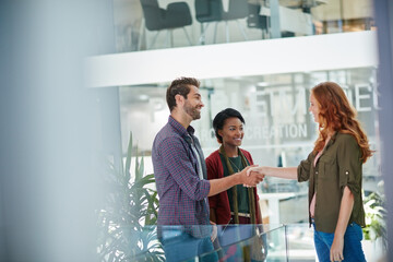 Poster - So nice to meet you in person. Shot of a team of creative businesspeople meeting a new teammember in the office.