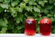 Two cans of fresh cherry compote from harvested ripe berry fruits. Pickled and preparation of preserves and canning. Natural natural background