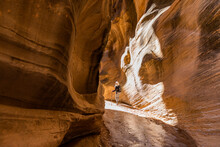 United States, Utah, Escalante, Rear view of senior female hiker exploring slot canyon in Grand Staircase Escalante National Monument