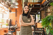 © whyframeshot - portrait of asian adult female woman wear apron standing at entrance of her workshop pottery studio incasual cloth relax smiling confident and warm welcome,asian woman with her home studio workshop