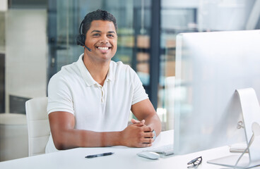 Wall Mural - ready to be of assistance. shot of a handsome young businessman sitting alone in his office and wear