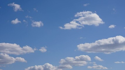Wall Mural - beautiful morning sunny clear blue sky with small fluffy white clouds flying overhead in clear blue 