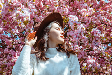 Canvas Print - portrait of beautiful caucasian woman with blooming sakura cherry trees