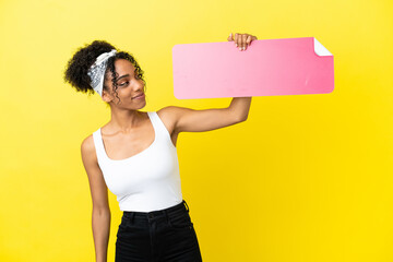 Sticker - Young african american woman isolated on yellow background holding an empty placard