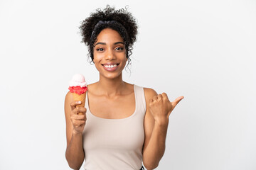 Wall Mural - Young african american woman with a cornet ice cream isolated on white background pointing to the side to present a product