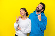 © luismolinero - Young caucasian couple isolated on yellow background pointing up with the index