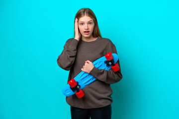 Teenager Russian girl isolated on blue background with a skate and doing surprise gesture