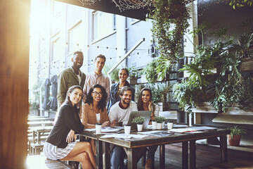Poster - We prefer our meetings in a relaxed setting. Portrait of a group of colleagues having a meeting at a cafe.