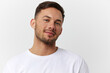 © SHOTPRIME STUDIO - Cheerful cute happy young tanned handsome man in basic t-shirt smile at camera posing isolated on over white studio background. Copy space Banner Mockup. People emotions Lifestyle concept. Portrait