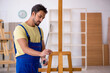 © Elnur - Young male repairman repairing easel at home