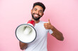 canvas print picture Young Brazilian man isolated on pink background holding a megaphone with thumb up