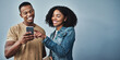 © Delmaine Donson/peopleimages.com - They like each other back. Studio shot of a young man and woman using a mobile phone together against a gray background.