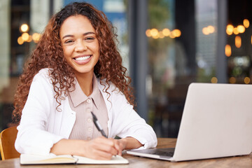 Wall Mural - Beauty and brains. Shot of a young businesswoman writing in a notebook while using a laptop at a cafe.