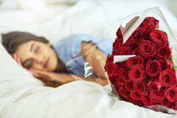 Poster - Shes got a surprise waiting for her. Cropped shot of an attractive young woman asleep beside a bouquet of roses in her bed.