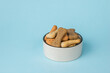 © kvladimirv - Cookies for dogs in a white bowl on a blue background.