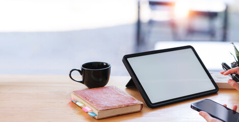Wall Mural - a businesswoman using digital tablet and holding smartphone over her office desk.