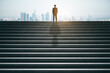 © Who is Danny - Back view of businessman on top of concrete stairs looking into the distance on daylight city background. Success and future concept.