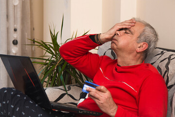 angry or frustrated man with credit card and laptop shopping online