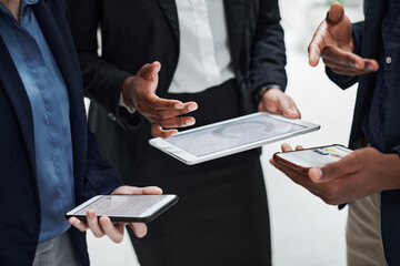 Wall Mural - Data processing minus the paper. Shot of a group of businesspeople using wireless devices during a meeting in a modern office.