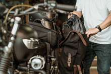 Rider Take The Clothes Out Of The Side Bag Or Saddlebags Of Motorcycle After Trip ,motorcycle Travel Concept. Selective Focus
