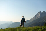 Fototapeta Las - Father and son hiking with a  view in the Austrian Alps. Active family vacation concept
