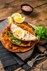 Wall Mural - Turkish cuisine made with thin dough and minced beef meat lahmacun on wooden board with herbs. Wooden background. Top view