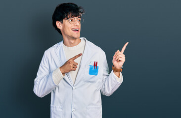 Poster - Handsome hipster young man wearing doctor uniform smiling and looking at the camera pointing with two hands and fingers to the side.