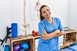 © Krakenimages.com - Young hispanic woman wearing physiotherapy uniform standing with arms crossed gesture at sport center