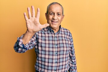 Canvas Print - Handsome senior man with grey hair wearing casual shirt showing and pointing up with fingers number five while smiling confident and happy.