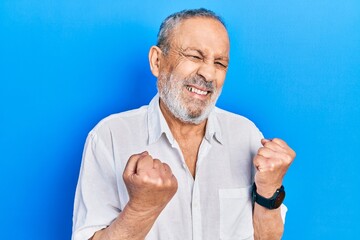 Poster - Handsome senior man with beard wearing casual white shirt excited for success with arms raised and eyes closed celebrating victory smiling. winner concept.