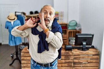 Canvas Print - Handsome senior man holding shopping bags at boutique shop hand on mouth telling secret rumor, whispering malicious talk conversation