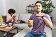 © Krakenimages.com - Hispanic father of interracial family drinking a cup coffee cutting throat with hand as knife, threaten aggression with furious violence