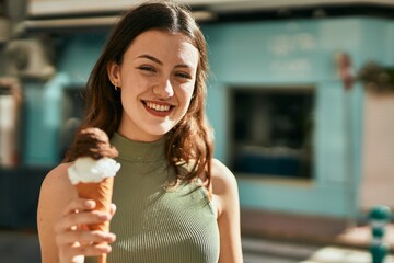 young caucasian girl smiling happy eating ice cream at the city.