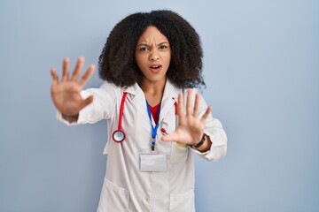 Poster - Young african american woman wearing doctor uniform and stethoscope doing stop gesture with hands palms, angry and frustration expression