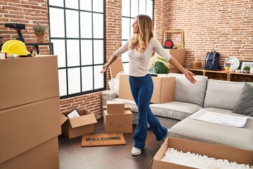 Canvas Print - Young blonde woman smiling confident standing with open arms at new home