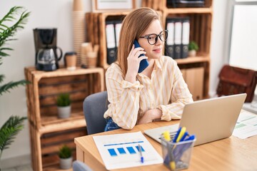 Poster - Young blonde woman business worker using laptop and talking on the smartphone at office