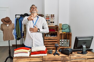 Poster - Middle age hispanic man working as manager at retail boutique laughing at you, pointing finger to the camera with hand over body, shame expression