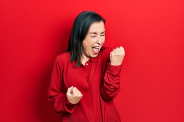 Poster - Middle age hispanic woman wearing casual clothes celebrating surprised and amazed for success with arms raised and eyes closed. winner concept.