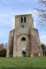 View of the Tour Carrée of the former Benedictine abbey of St Winnoc in Bergues, Nord, France, on a sunny spring day. The tower is now part of public garden.