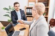 © Krakenimages.com - Mother and son business workers shake hands at office