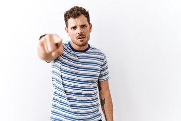 Sticker - Handsome young man standing over isolated background pointing displeased and frustrated to the camera, angry and furious with you