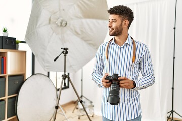 Poster - Young arab photographer man smiling happy using reflex camera at photo studio.