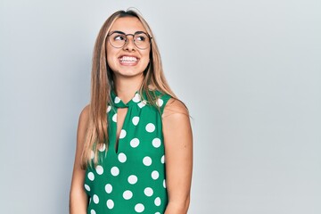 Sticker - Beautiful hispanic woman wearing elegant shirt and glasses looking away to side with smile on face, natural expression. laughing confident.