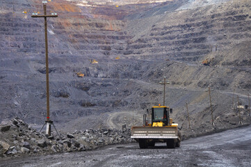 Wall Mural - Wheeled bulldozer moves along the roads of an iron ore quarry