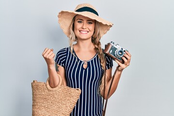 Poster - Beautiful young blonde woman holding vintage camera smiling with a happy and cool smile on face. showing teeth.