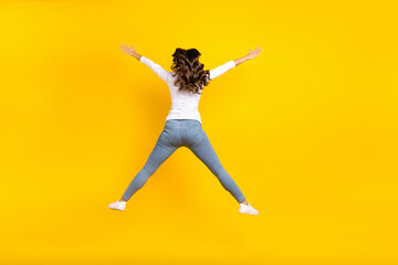 Canvas Print - Photo of shiny funky woman wear white shirt jumping high like star isolated yellow color background