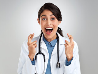 Sticker - A bit of hope goes a long way towards healing. Studio portrait of a young doctor crossing her fingers against a grey background.