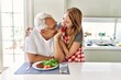 © Krakenimages.com - Middle age hispanic couple smiling happy eating beef with salad at the kitchen.