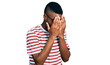 © Krakenimages.com - Young african american man wearing casual t shirt and glasses with sad expression covering face with hands while crying. depression concept.